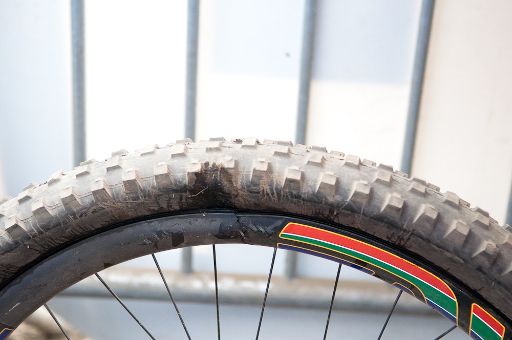 KARBONFLISER: Det er usikkert om Greg Minnaar punkterte før eller etter trynet. Det gikk bra me Greg, men hjulet fikk seg en trøkk. Foto: Øyvind Aas. gregbakhjul