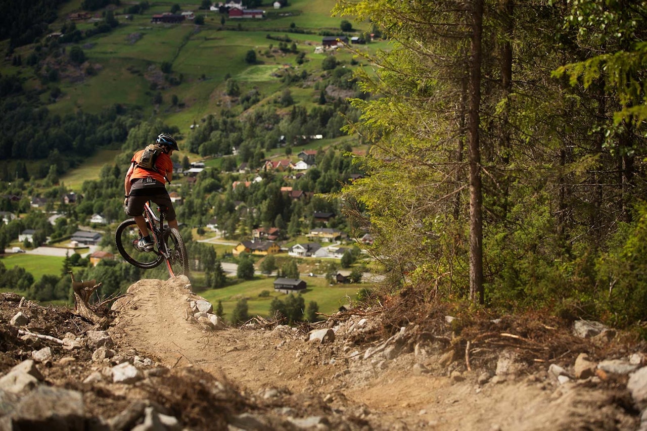 Vegard Breie får luft under hjulene på vei ned mot hjembygda Ål, på stien han selv har bygget og gitt navn til. / Stisykling i Norge. Vegard Breie får luft under hjulene på vei ned mot hjembygda Ål, på stien han selv har bygget og gitt navn til. / Stisykling i Norge.