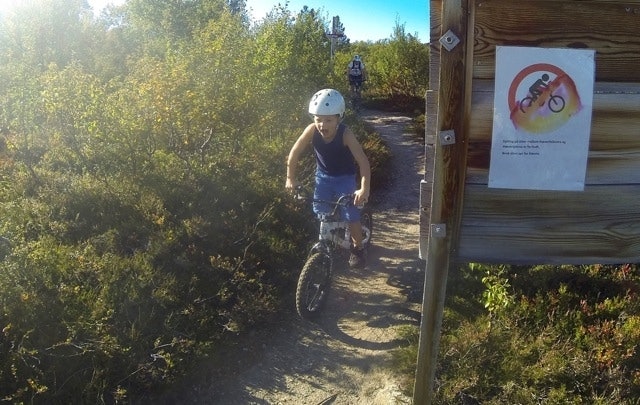 TULL: 5-åringen på vei tilbake etter å ha sykla på stien hvor sykling er «forbudt». Tre ganger passerte vi grupper med turgåere, to av de tre gruppene var barnefamilier, og hver gang var stemninga på topp. Foto: Tore Meirik 12-17-20_fancybox
