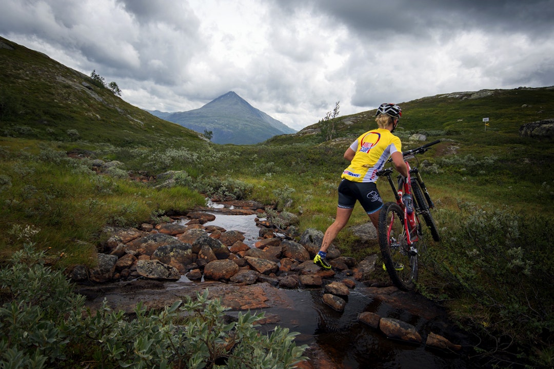Damevinneren Heidi Sanstå krysser en bekk med Gaustatoppen i bakgrunnen Damevinneren Heidi Sanstå krysser en bekk med Gaustatoppen i bakgrunnen