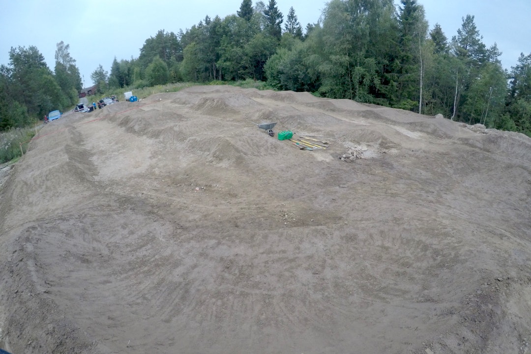 Kristoffer Haugland, Niklas Andersen og gravemaskinen deres i Pumptrack Norge ofret helga for grunnarbeidet på anlegget i Mysen. Nå gjenstår bare litt klapping før alle elementene er klare. Foto: Arne Bjørn Vestavik Pumptrack Mysen - Foto Arne Bjørn Vestavik 1200x800