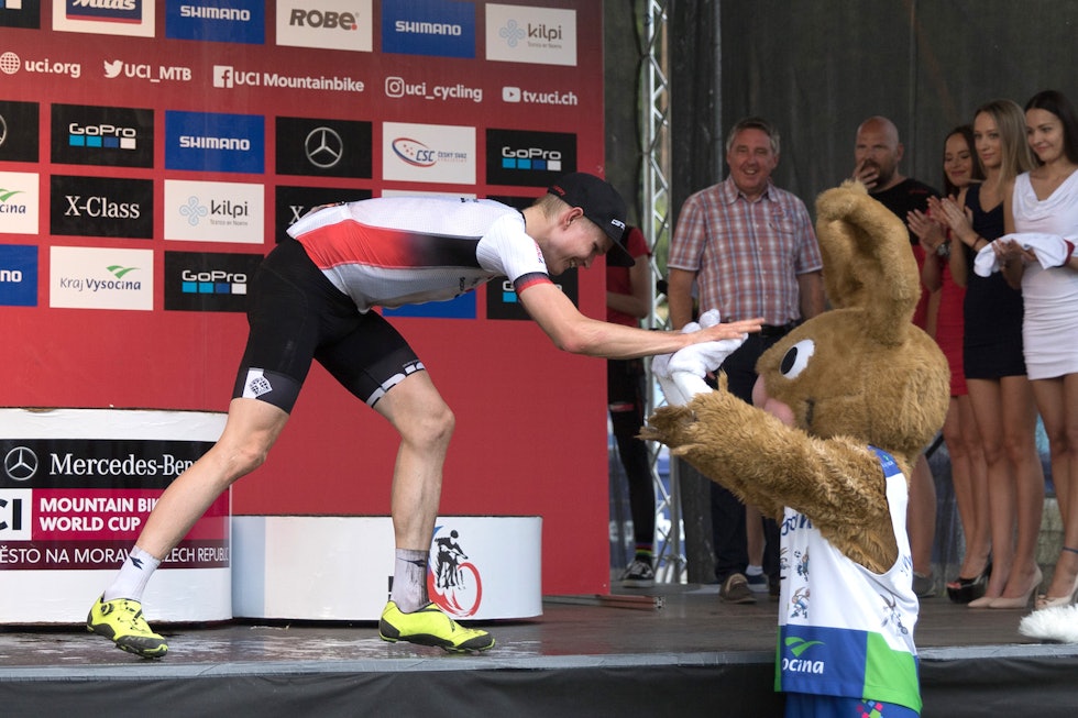 Petter Fagerhaug gir verdenscupmaskoten en high five under premieutdelingen i Nove Mesto. Foto: Bengt Ove Sannes Petter Fagerhaug - mascot - WC Nove Mesto 2018 - Bengt Ove Sannes 1400x933