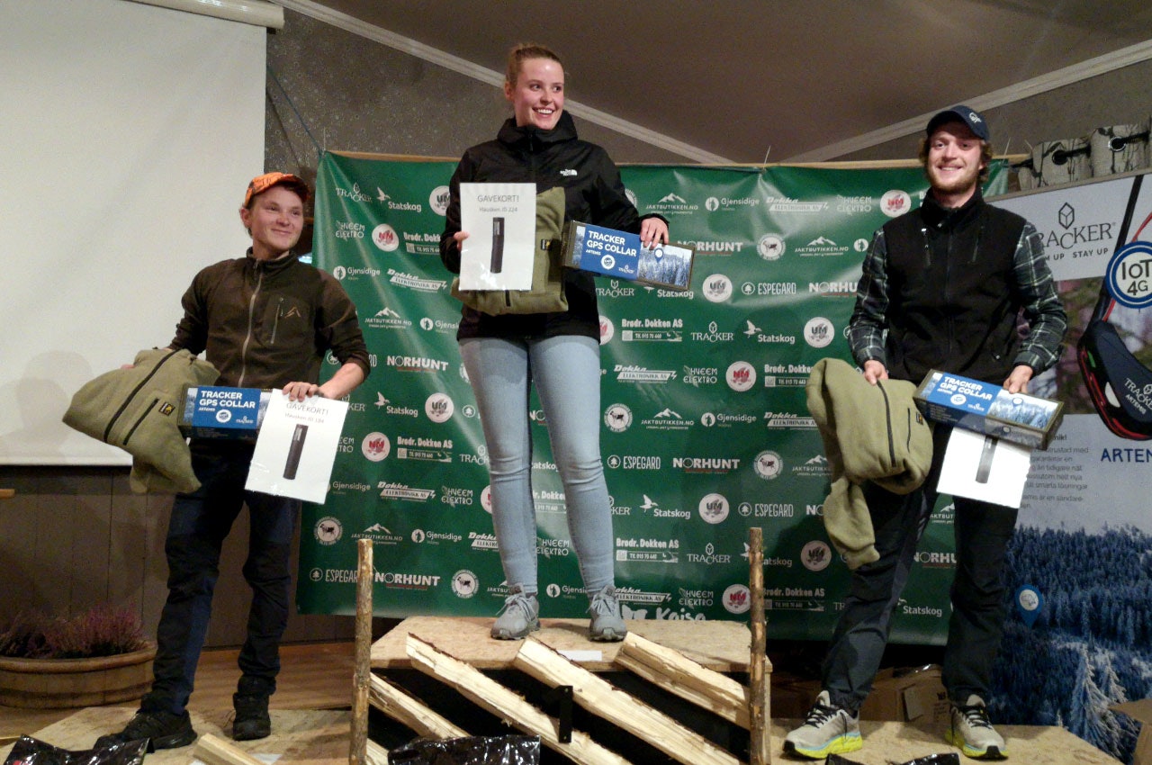 På pallen: Sara Kjensrud Auren fra Hallingdal og Valdres Elghundklubb vant ungdomsmesterskapet i løshund (UM 2021) med jämten Veikulåsens H R Felix. Her er hun på pallen sammen med sølvvinner Lars Erik Olsen og bronsevinner Gjermund Sæthre. (FOTO: Elin Elg Trøen) Tre unge hundeførere Sara Kjensrud Auren, Lars Erik Olsen, Gjermund Sæthre på pallen ungdomsmesterskapet i løshund (UM 2021)