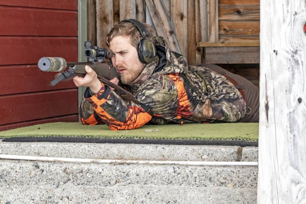 Jeger i liggende jegerstilling sett forfra sikter med rifle og skytestropp