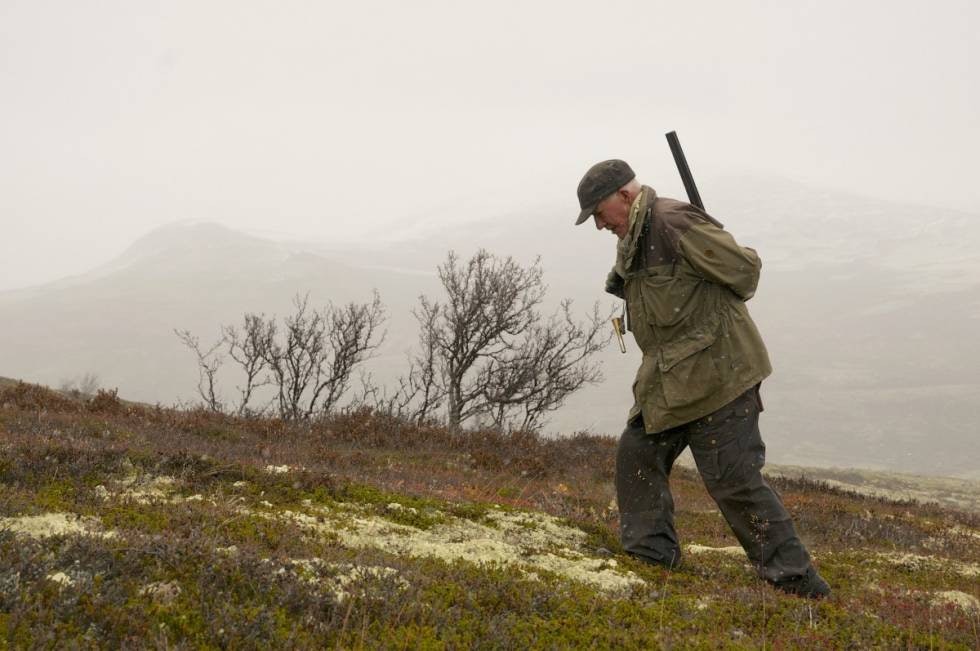 Mot vinter: Snøbygene kommer sigende innover fjellet. Jegeren går mot bilen og avslutter jaktdagen. Mot vinter: Snøbygene kommer sigende innover fjellet. Jegeren går mot bilen og avslutter jaktdagen.