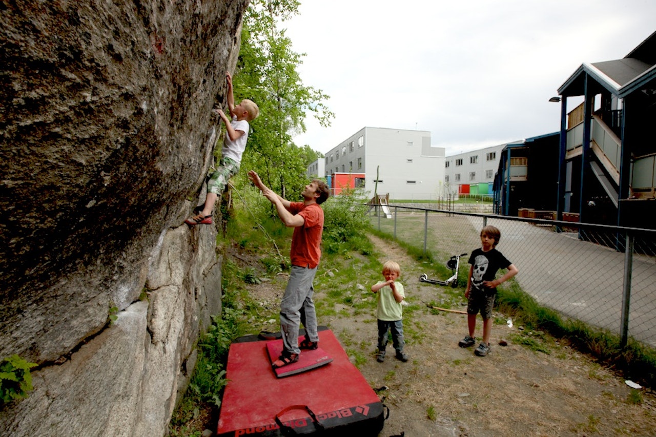 Trym Landmark klatrer på barnehageveggen. Einar Landmark spotter. Foto: Dag Hagen