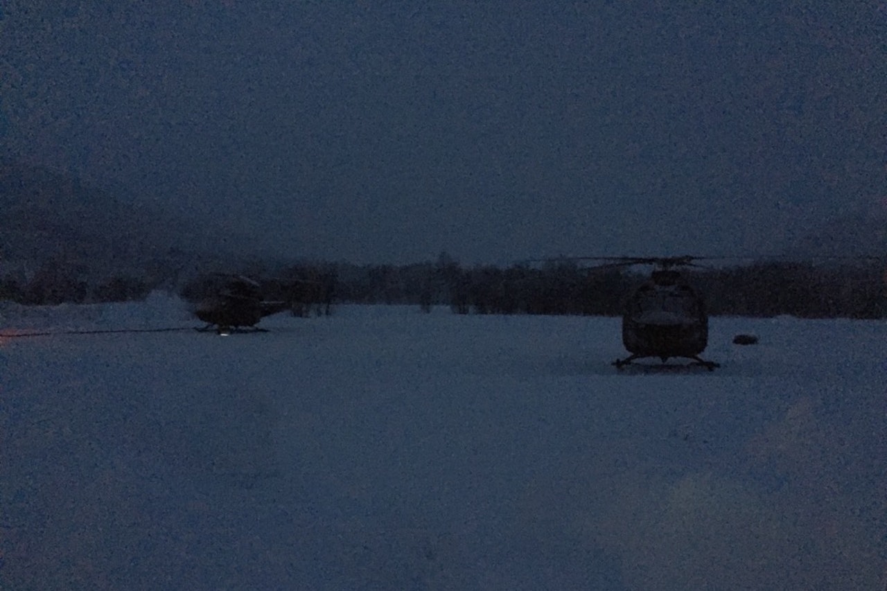 Helikoptrene som bistår i operasjonen med å få de savnede skredtatte skiløperne ned fra Blåbærfjellet har parkert for dagen. Foto: Sjur Melsås