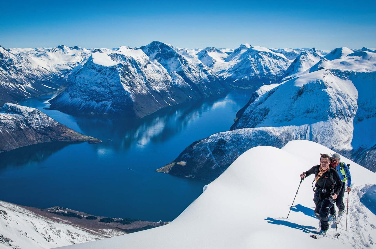 Stig Helset og Sindre Rudi på veg opp mot Lisjedalshornet. Fjella på Rånahalvøya reiser seg på andre sida av fjorden. Foto: Håvard Myklebust