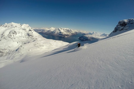 Odd Magne Fagerland kjører ned østsiden av Snøtinden med Lavangen og Langlitinden i bakgrunnen. Odd Magne Fagerland kjører ned østsiden av Snøtinden med Lavangen og Langlitinden i bakgrunnen.
