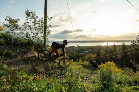 BEST EGNET: – I 2013 dro jeg og Andreas Braaten til alle skianleggene rundt Oslo for å se hvilket som egnet seg best for sykling. Vardåsen var best. Det er mange som bor i sykkelavstand, og det er kort reisevei for folk fra Oslo, Drammen, Asker, Bærum og Lier. I tillegg har du toget som gjør tilgjengelig for de under 18. Og så har jo Vardåsen kanskje en av de to-tre beste utsiktene over Oslofjorden, sier Trond Hansen. Den tidligere proffsyklisten er primus motor bak bygginga i Vardåsen. Her leder han an nedover foran Frikk Hess Bolstad. Foto: Vegard Breie Vardåsen sykling