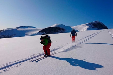 FARTSGLADE: Frode Skjeldal og Rune Røsten har tatt fri fra treningssamlingen til Kjelsås alpin og sporer nysnøen over Styggebreen med Galdhøpiggen i bakgrunnen. 