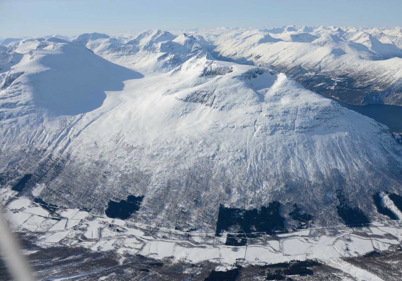 MELDER SNØ: Toppen av skifjell som Dronningkrona får påfyll av snø i juli. Her er Dronningkrona sett fra vest. Foto: Ludvig Killingberg. / Trygge toppturer. Dronningkrona