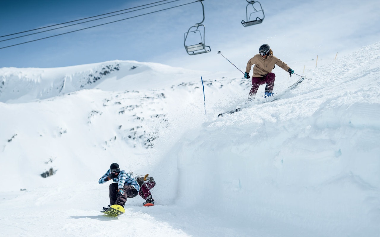 SLØSJ-SHRED: Med ski på beina har Albin Petterson Bråthe gode forutsetninger for å spraye snowboarderne Joel Olovsson og Harry Kingsley-Jones. Vi våger påstanden: Stryn sommerskisenter har Norges mest lekne tråkkemaskinspor. Foto: Emil Eriksson