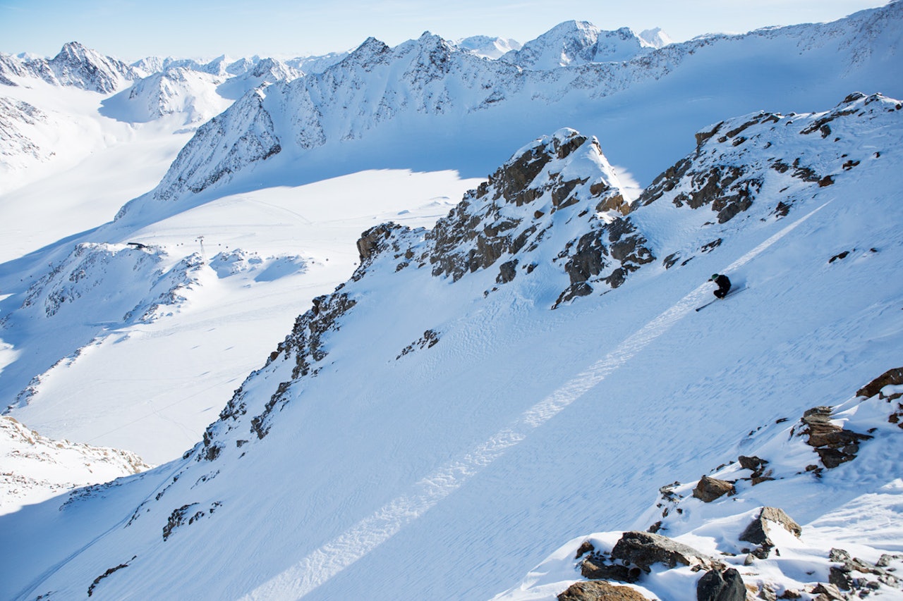 PÅ RYGG: I deilig snø setter Magnus Tveito fart fra ryggen under heiswiren og ned mot breen med Østerrikes høyestliggende alpinløyper under. Foto: Tore Meirik