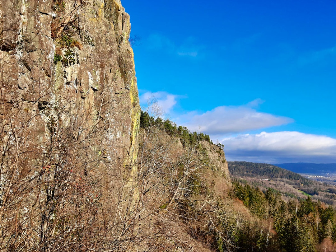 MOT KJEMPESVAET: Den gule merkingen kan ses i området fra ruta Jonathan og bort til Kjempesvaet, som ses i profil på dette bildet. Foto: Lisa Kvålshaugen Bjærum kolsås Helle Siljeholm Jon Gangdal Marius Morstad klatring