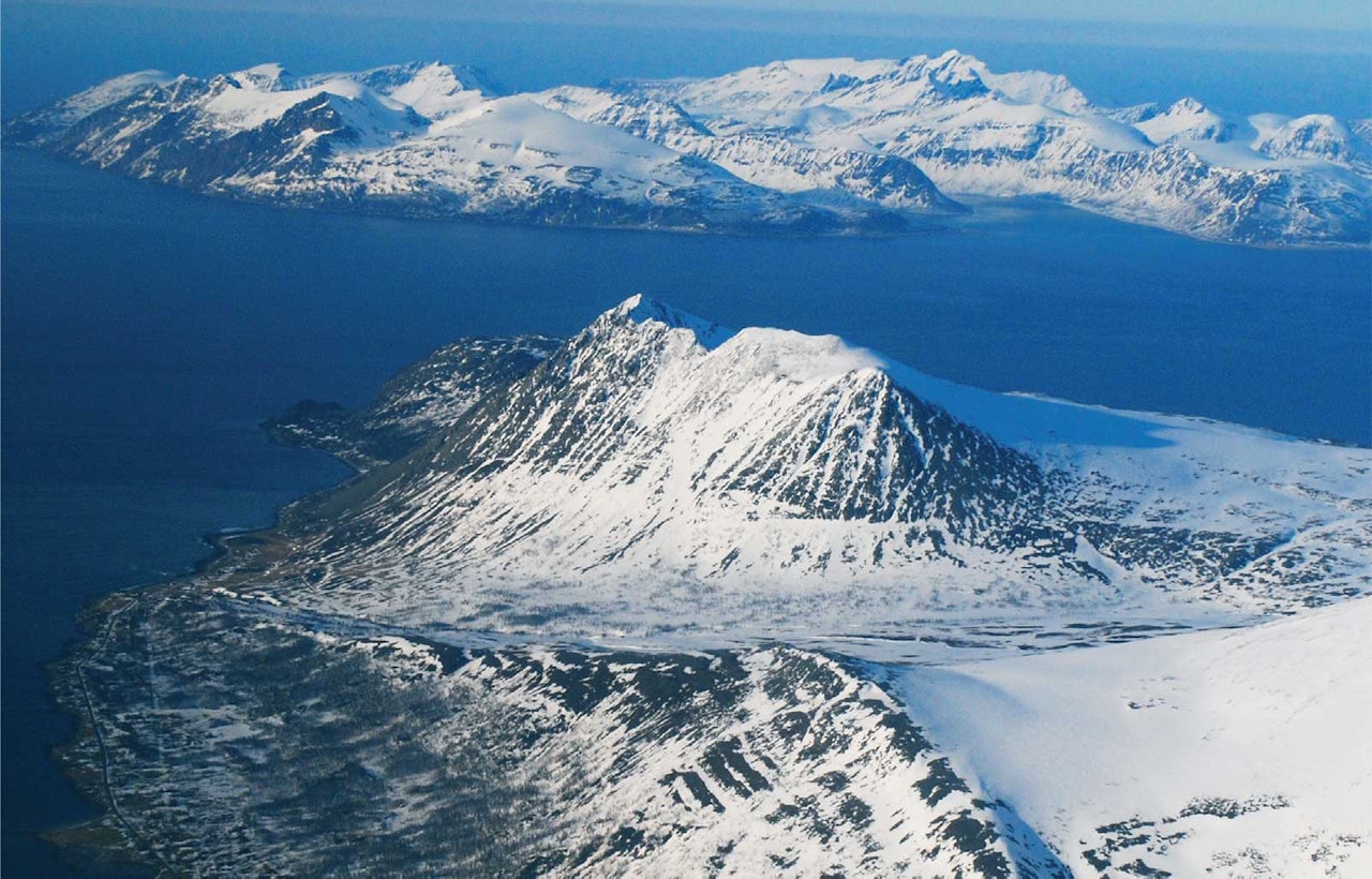Russelvfjellet sett fra sørvest. Arnøya i bakgrunnen. Foto: Lorentz Mandal. / Trygge toppturer.