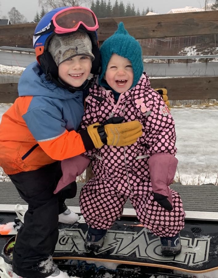 Syskenkjærleik i barnebakken. Synnøve (3) på brett og Sverre (6) på ski. Foto: Privat Barneski på Voss