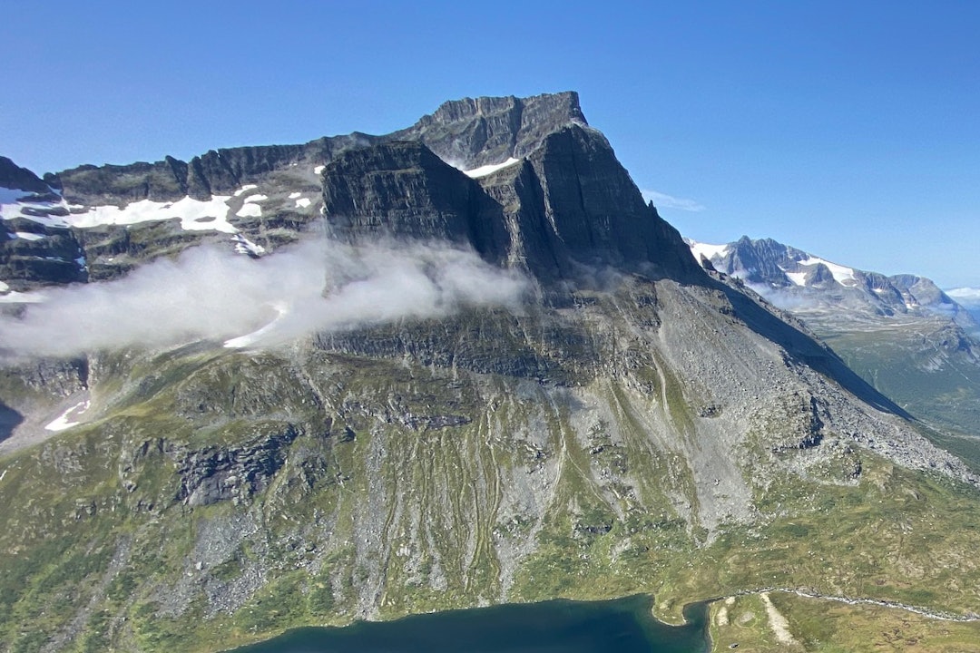 SKARFJELLET: Sørtoppen til venstre, stortoppen bak og midttoppen midt på. Den store klassiker-ruta er Sørøsthjørnet på sørtoppen. Det er mange ruter i sørveggen (ikke synlig på bildet) og veggene i skygge på sør- og midttoppen. Det er noen klatreruter på stortoppen også, men de er ikke like mye gått. Nordveggen på stortoppen (ikke synlig på bildet) er temmelig seriøs og gås sjelden. Foto: Tore Meirik Skarfjellet
