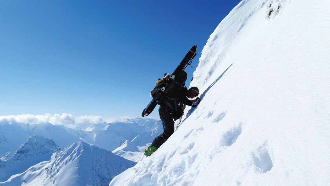 NESTEN OPPE: Espen Nordahl med skiene på sekken og isøks i hånda de siste bratte meterne opp til toppen av Tafeltinden. Bilde: Torben Rognmo