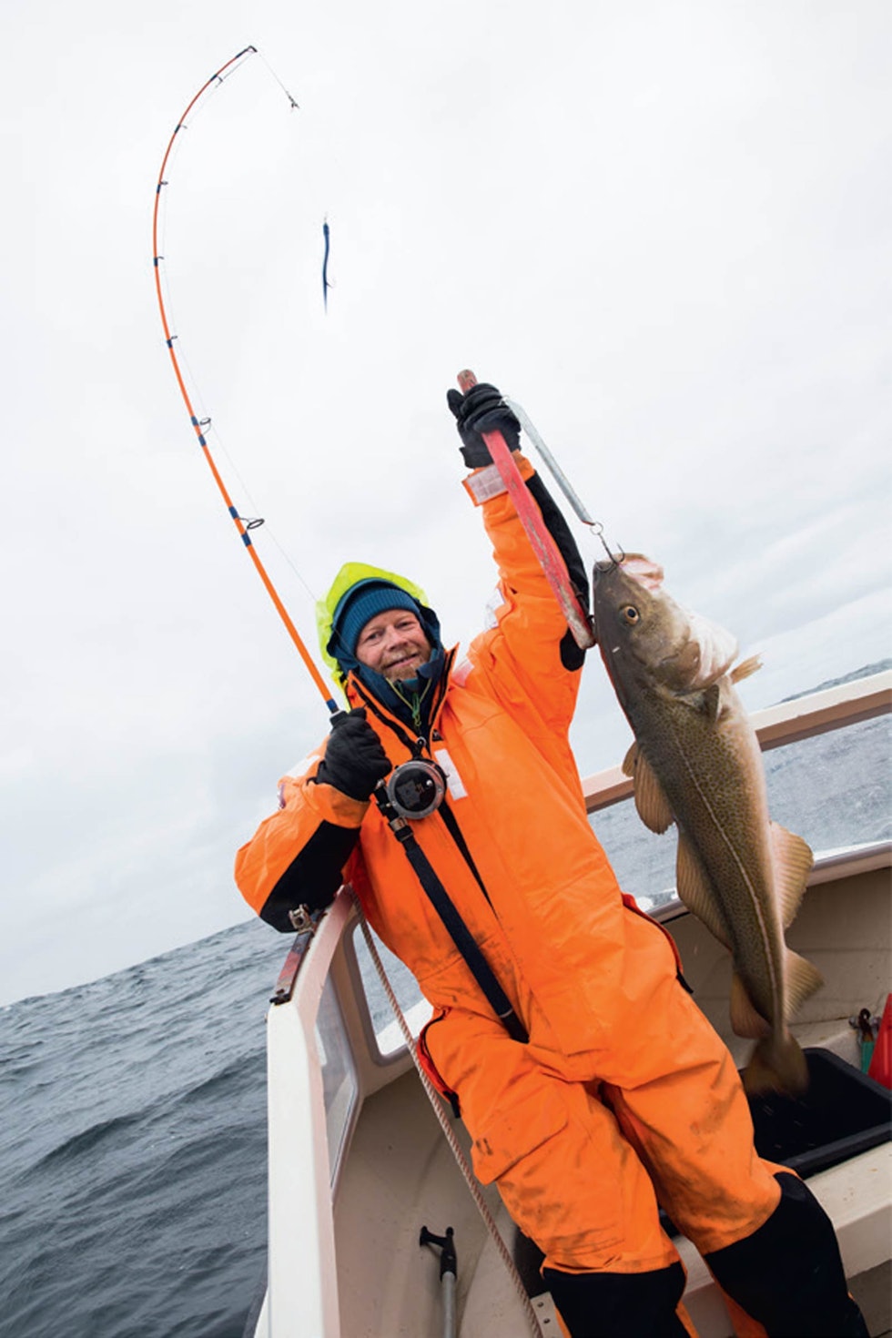 SE TORSKEN: Ikke rart fiskestanga bøyer seg når Espen Sollien drar i land en velvoksen torsk fra havet.
