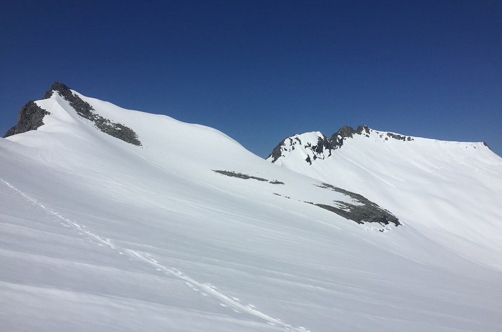 VINTERLAND: Sola stekte, temperaturen var alt for høy og miksen av solkrem og svette svei i øynene. Likevel er det masse snø i Sunndalsfjella – dette er Trolltind (til venstre) og Åbittind torsdag 11. juni 2020. Foto: Tore Meirik topptur sunndal