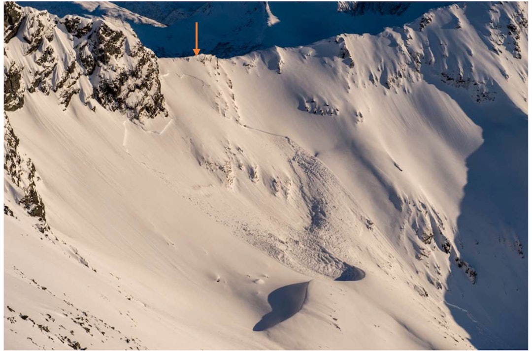 Pilen peker på sporet inn i skredet. Skredtatte blir ført videre ned mot høyre i bildet og løser ut skredet som vises i sol/skygge parti nede i høyre hjørne. Pilen peker på sporet inn i skredet. Skredtatte blir ført videre ned mot høyre i bildet og løser ut skredet som vises i sol/skygge parti nede i høyre hjørne.