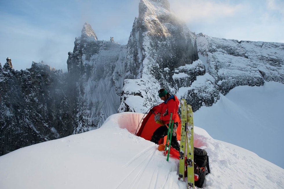 Tett på Trollveggen. Elling Heiberg forbereder seg til en komfortabel natt på toppen av Nordre Trolltind. Bak sees store trolltind snøkjeglen fra lavskarrenna nede til høyre. Foto: Johan Wildhagen Nordre-Trolltind-Toppturer-i-Romsdalen-2