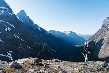 PÅ VEI NED: Sent på sommeren må man regne med å gå litt med skiene på sekken. Henning Svoren nyter utsikten over Isterdalen etter skitur i juni. Foto: Ståle Johan Aklestad Trollstigen