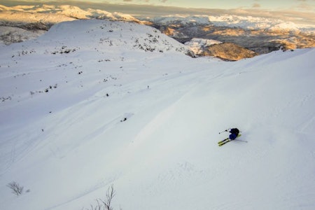 Bilde 1: Kari Sølberg Ellingsen på vei ned fra Gullfjellstoppen i god snø. I bakgrunnen ses Kråfjellet, som kan være vel verdt et besøk. Foto: Øystein Bjelland Gullfjellet topptur randonee guide bergen