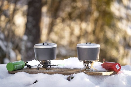 Test av multifuelbrennerne: Optimus Polaris Omnifuel og MSR Whisperlight Universal er begge gode valg når du er avhengig av noe som både smelter snø og varmer i kulda.  Optimus Polaris Omnifuel og MSR Whisperlight Universal på planke i snøen