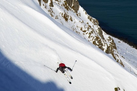 KYSTNÆRT: Martin Gammelsæter nyter nærheten til havet på Flakstadøya. Sekunder senere støter han på hardere underlag og gjennomfører resten av skituren med hodet først. Foto: Thomas Kleiven Topptur Lofoten Flakstadøya
