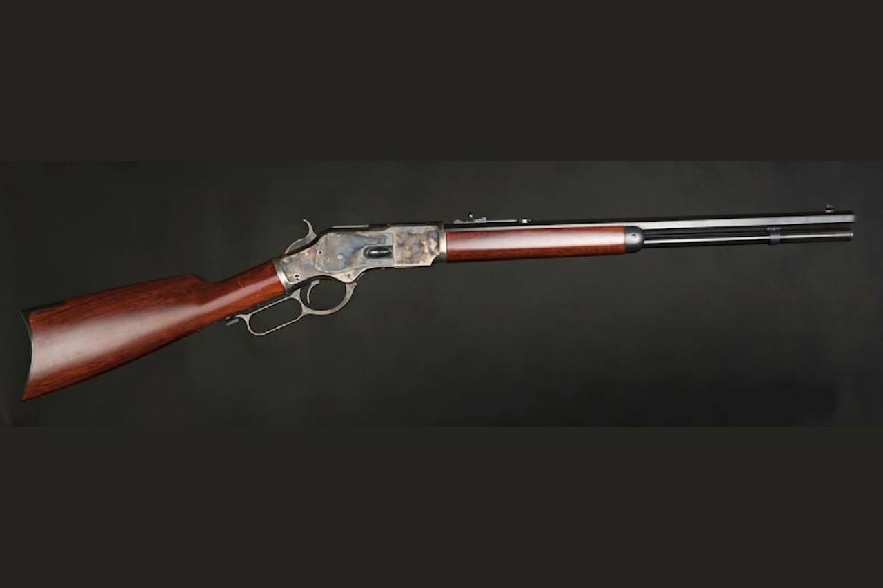 Winchester 1873 Short Rifle sett fra siden på sort bakgrunn