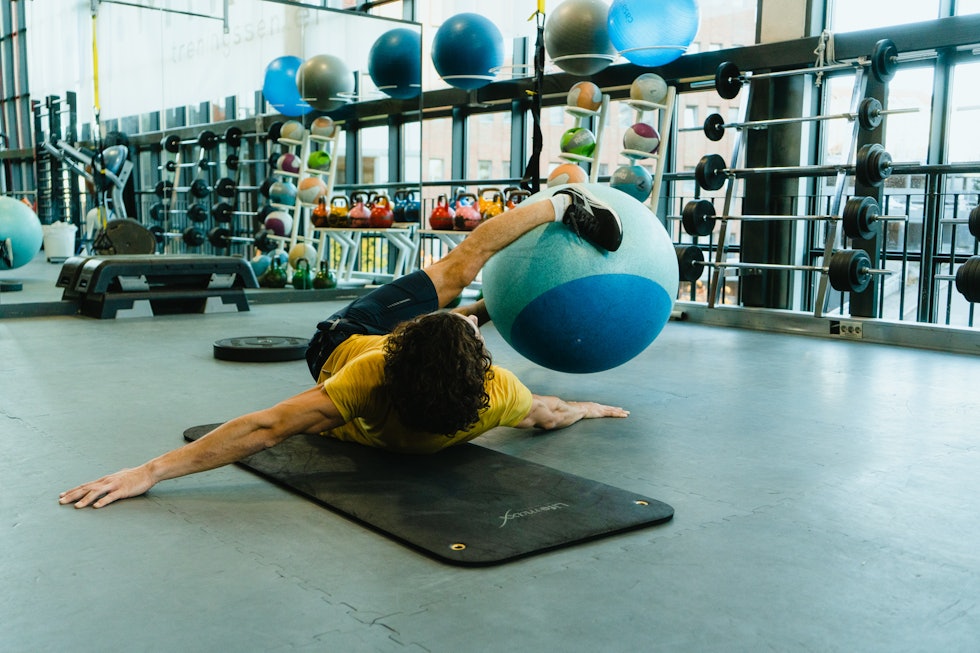 KRYSS MED BALL: Legg deg på ryggen på en matte med fitnessballen mellom føttene og sving ballen fra side til side. Foto: Christian Nerdrum