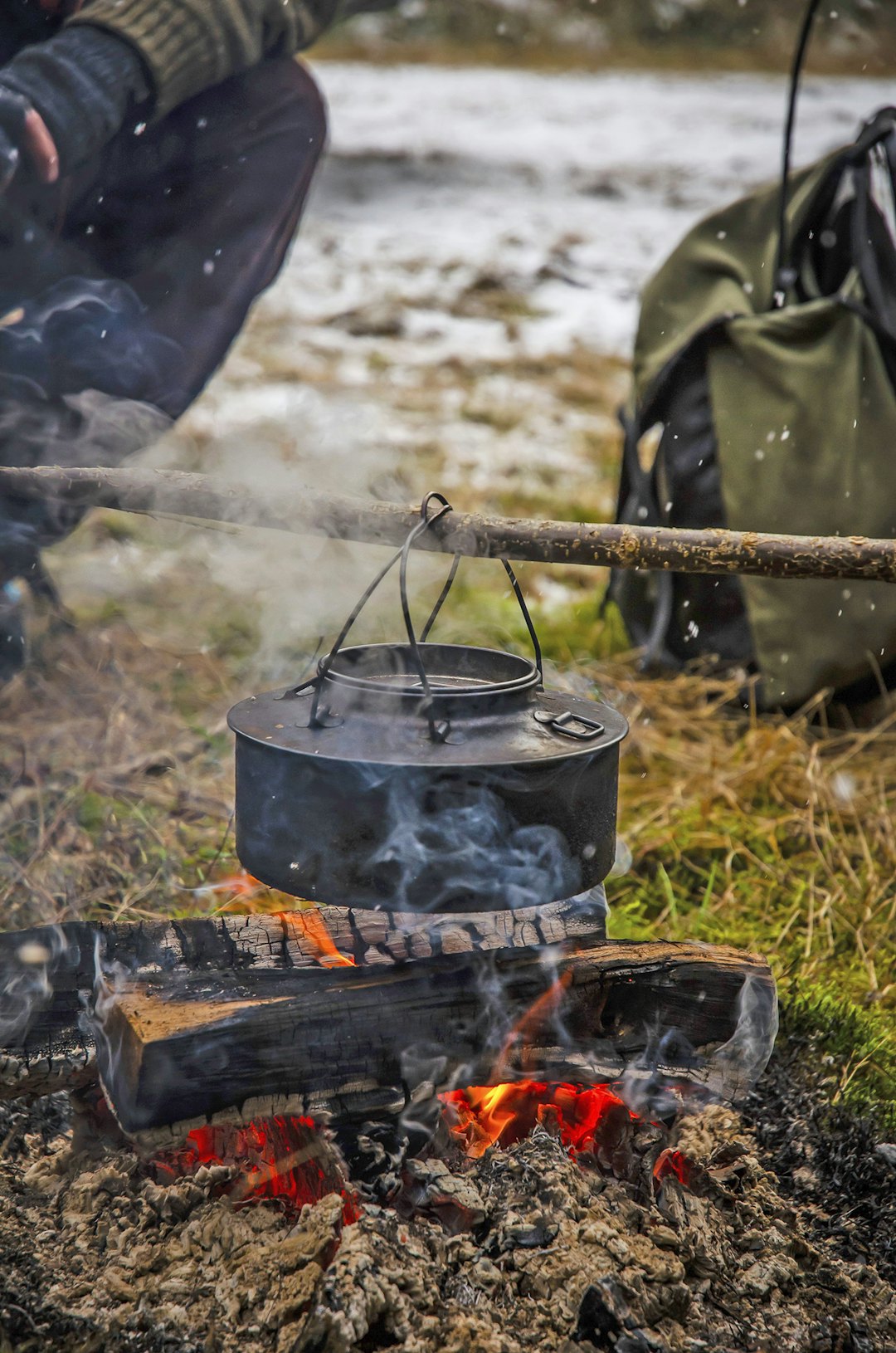 Tid for en tår: En godt innsotet svartkjele løftes over bålet. Sjelden smaker kaffen så godt som her ute i skogen. Tid for en tår: En godt innsotet svartkjele løftes over bålet. Sjelden smaker kaffen så godt som her ute i skogen.