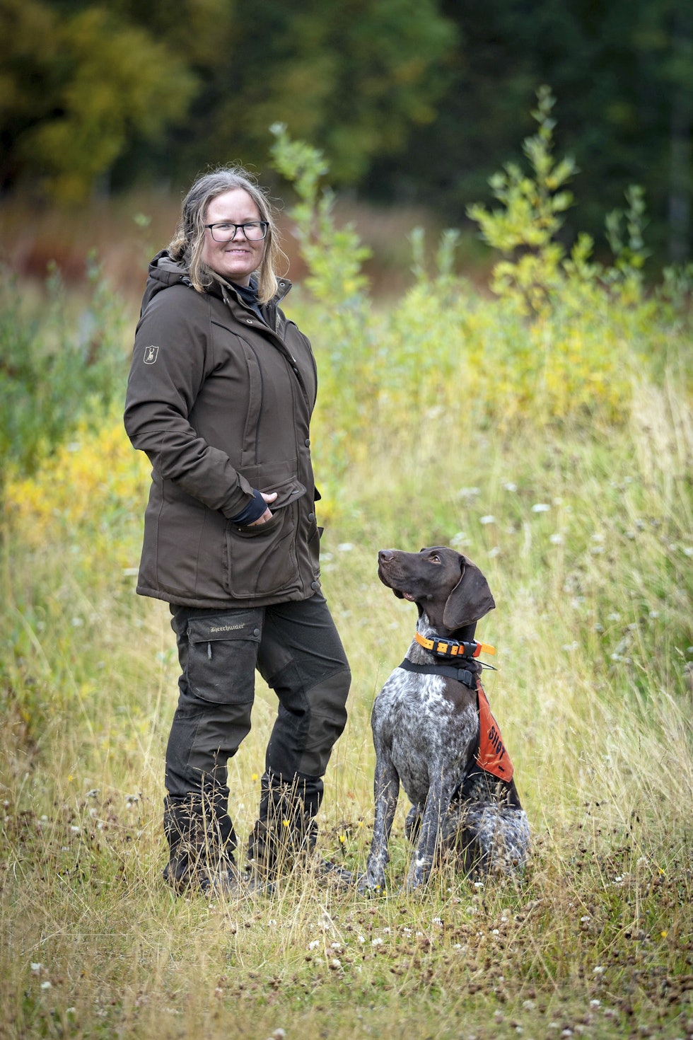 Jeger ikledd Deerhunter Lady Mary jaktjakke ved siden av en hund