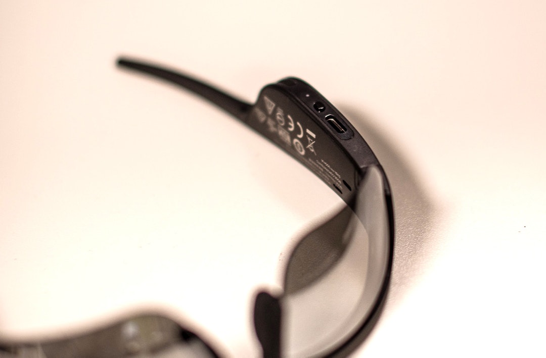 ENKELT: Brillene lades med USB-C. Den lille knappen styrer de fleste av funksjonene på brillen, utenom volumet. Foto: Henrik Alpers. 