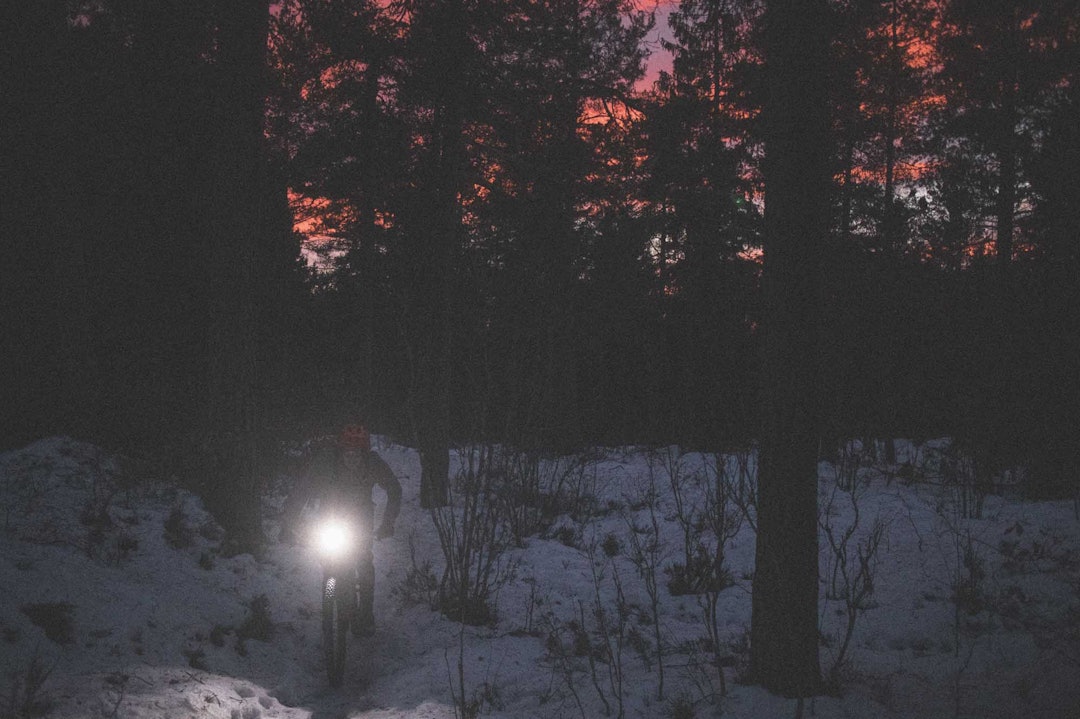 SISTE LYS: Øyvind Aas får med seg solnedgangen over Oslofjorden bak seg, og skrur på lykta for en opplevelse utenom det vanlige de neste timene. Foto: Kristoffer H. Kippernes. stisykling piggdekk oslo