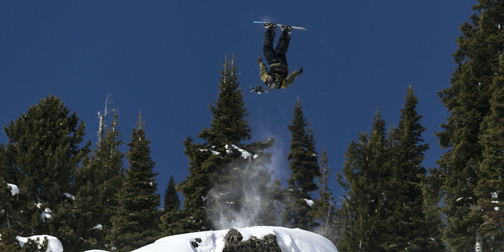 DRØY PRODUKSJON: Det kan best sammenliknes med et dataspill, å se verdens beste frikjørere på snowboard «fly» ned i løypa i Natural Selection. Foto: Natural Selection Tour Snowboarder i ferd med å treffe drone