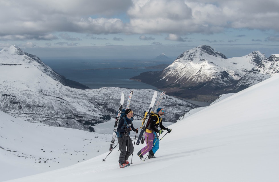 FÅR SKREDVARSEL: Topptur på Medtinden i Helgeland. Foto: Ole Martin Krokstrand To karer på topptur med ski på sekken og fjord i bakgrunnen