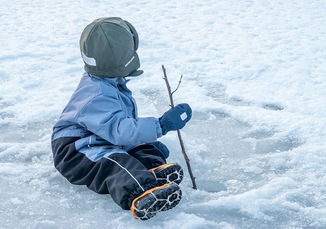 Bilde av barn på isen med brodder på skoene