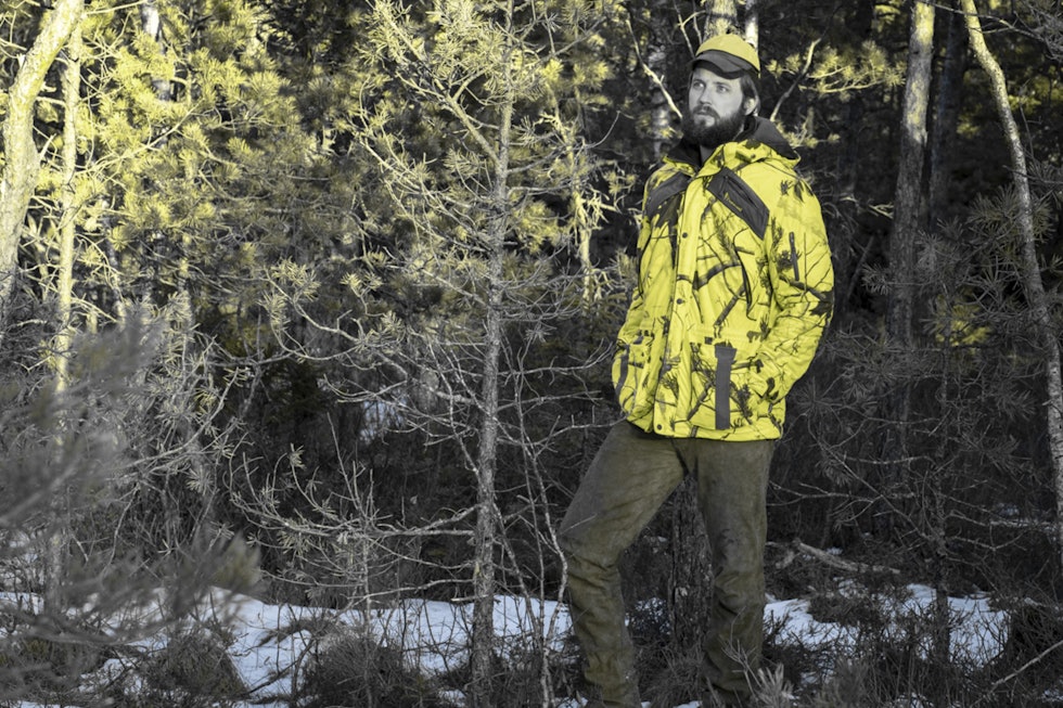 Jeger i signalfarget kamuflasje jakke, manipulert for å illustrere hjorteviltets syn