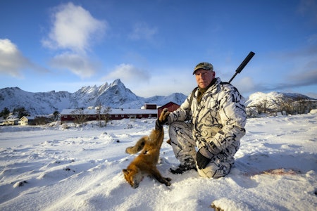 Revejeger med bratte, snøkledte fjell i Lofoten rundt seg