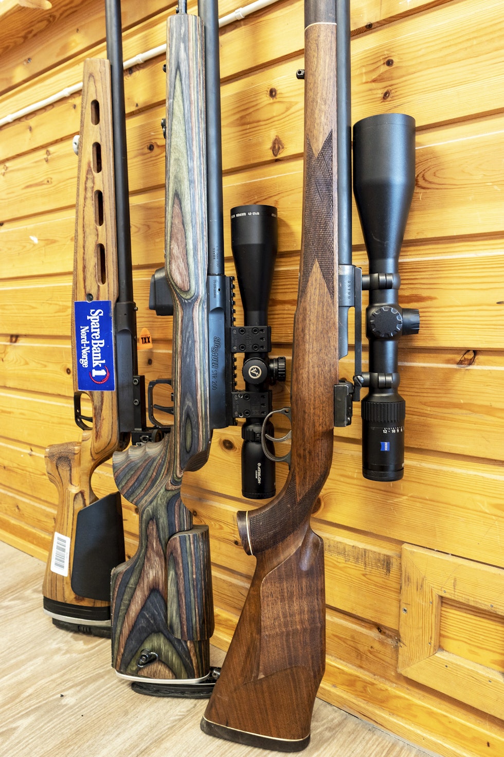 Likt grunnlag: I kikkertklassen stiller alle deltagere likt, selv om utstyr kan variere fra en gammel Mauser til rene konkurransevåpen. Men ikke la det avskrekke deg fra å prøve. Jaktrifler og DFS-rifle lent mot vegg.