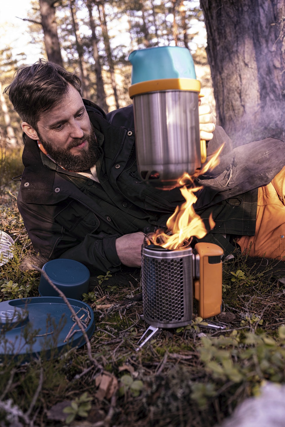 Full fyr: Når Biolite Campstove Complete Cook Kit først brenner, går det godt unna med kvist. Mann holder kjele over Biolite Campstove Complete Cook Kit