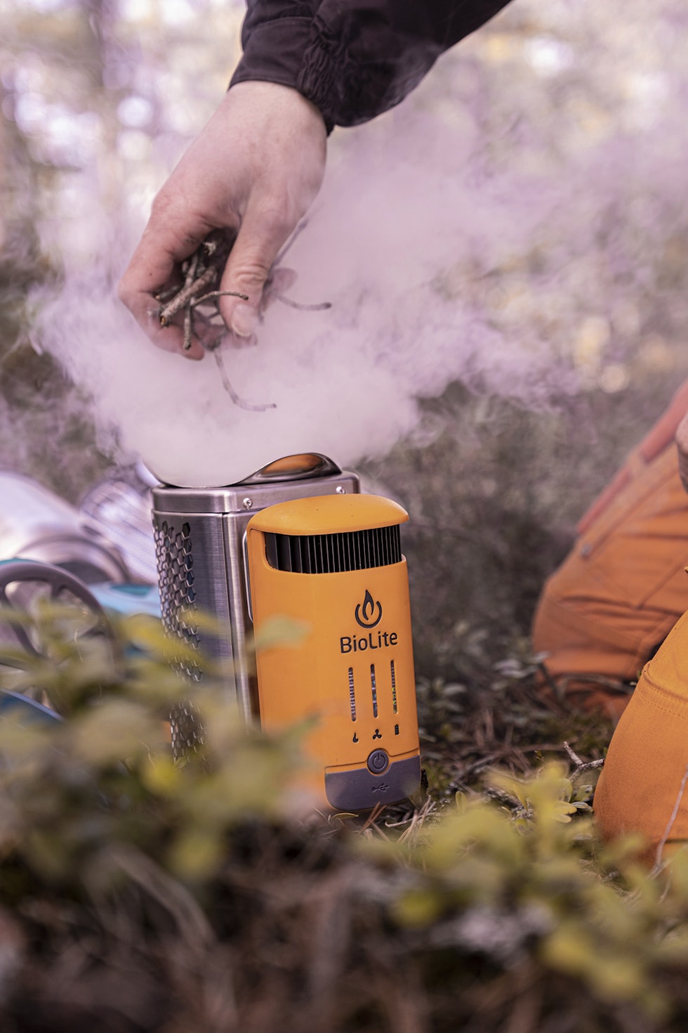 Røykfullt: Om kvisten ikke er tilstrekkelig tørr, blir det fort mye røyk fram til Bioliten har fått skikkelig fyr. Hånd som putter kvist i kvistbrenner Biolite Campstove Complete Cook Kit