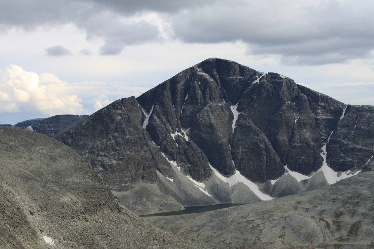 Den 700 meter høye nordveggen på Rondslottet styrter ned i et botntjern. Den bratte fjellsiden er Rondanes høyeste stup