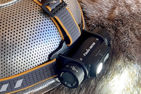 FENIX HM70R: Og det blir mer og mer lys. Fenix HM70R er ei fleksibel hodelykt som gir både langlys og lang levetid. Fenix HM70R hodelykt med LED-lys og li-ion batteri fotografert på et dørslag