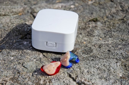 Hørselslaben Jegern aktive ørepropper foran plasteske på en stein