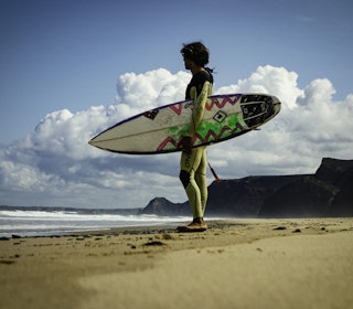HVA SLAGS DRAKT? Hvis du er litt i tvil, og vil bruke drakten til ulike vannaktiviteter, er det best å velge seg en drakt som er laget for surfing. Foto: Christian Nerdrum Gutt med surfbrett under armen