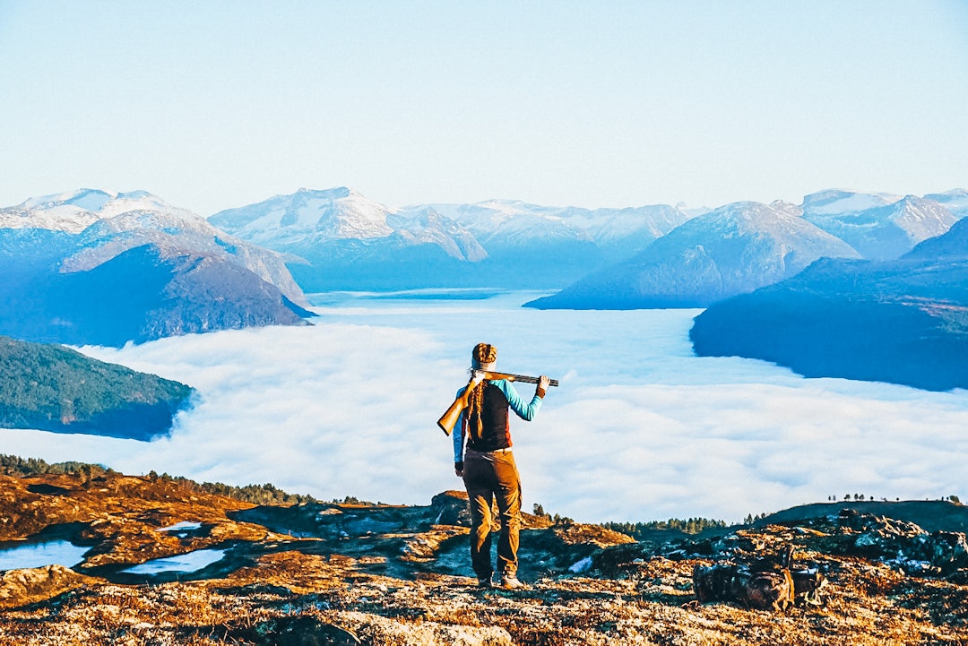 Rita Gausemel får 2. plass for dette flotte bildet fra Stryn. Kvinnelig jeger med hagle ser utover fjell med tåkelagt dal.